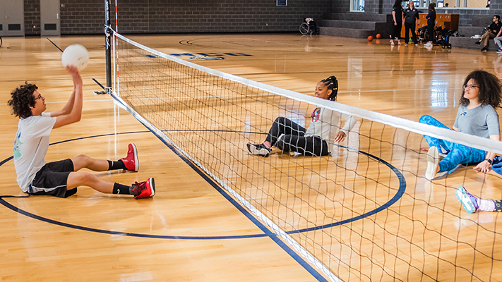 Students playing adaptive volleyball.
